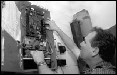 A man is shown installing an electrical alarm system.